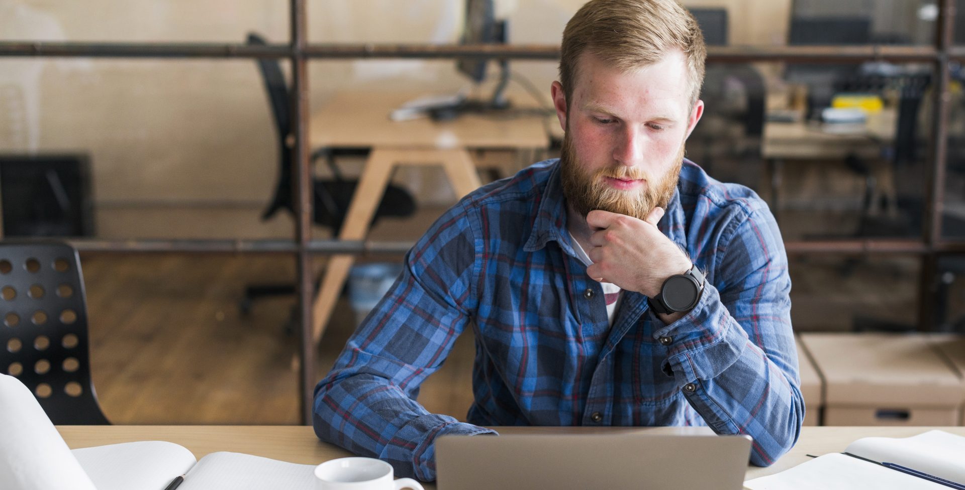 bearded-man-working-laptop-workplace
