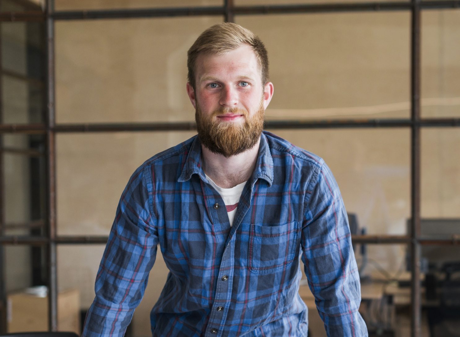 front-view-smiling-businessman-standing-front-desk