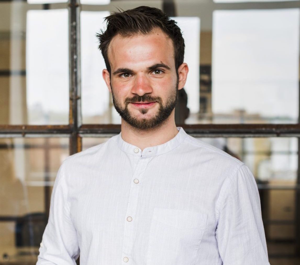 portrait-smiling-man-holding-digital-tablet-looking-camera